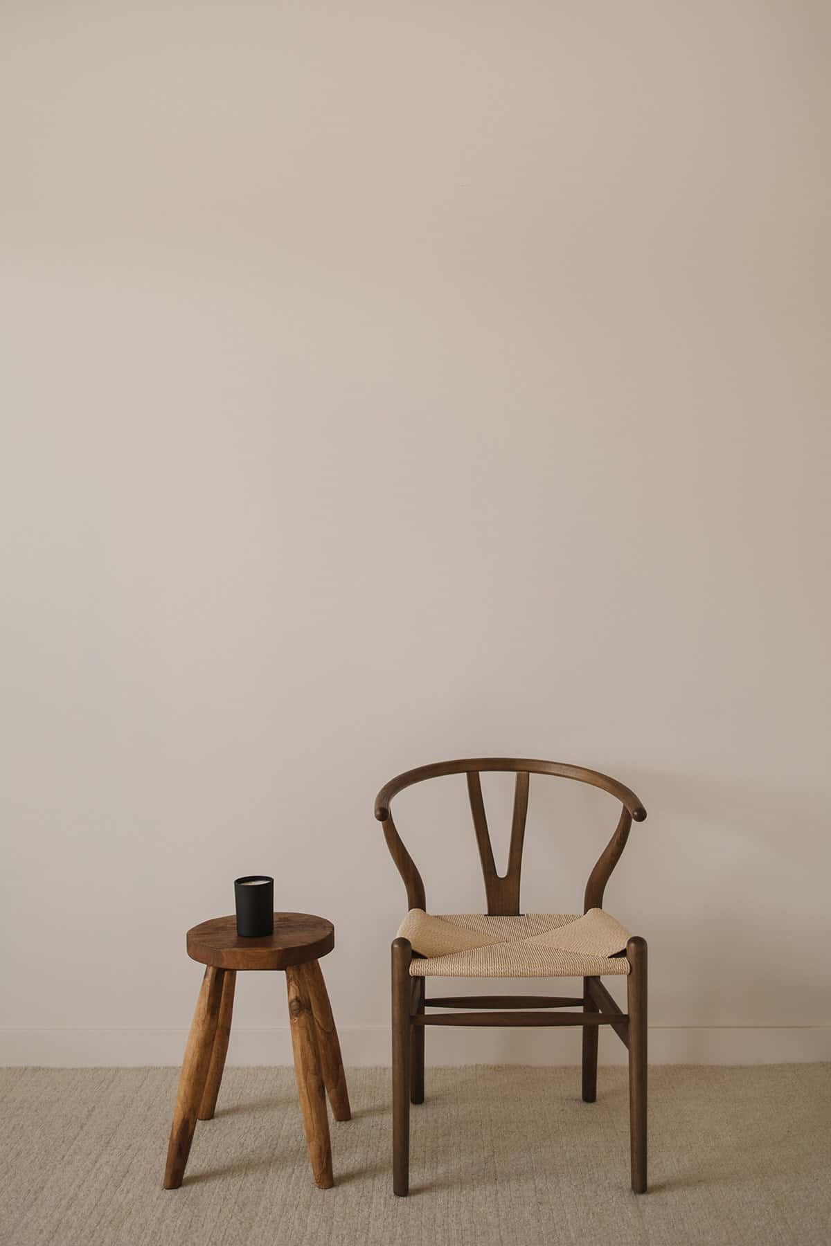 Stylish wooden chair with beige cushion and small wooden side table in minimalist home decor.