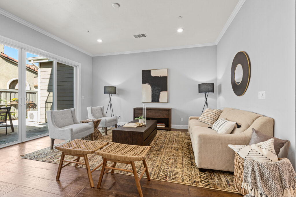 Living room including sofa, chairs, tables, and artwork.