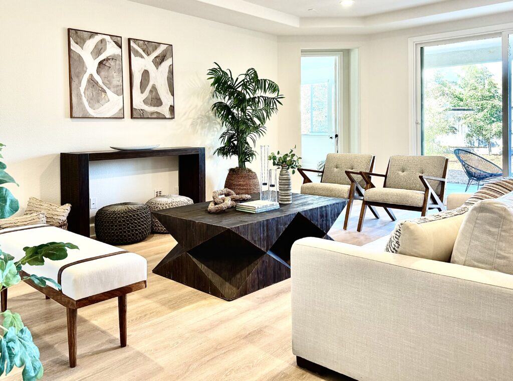 Living room with a sofa, cofee table, chairs, and console with modern art above